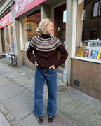 Celeste Sweater on näyttävä, moderni ja taidokkaasti suunniteltu kirjoneulevillapaita, jota koristaa upea pyöreä kaarroke.