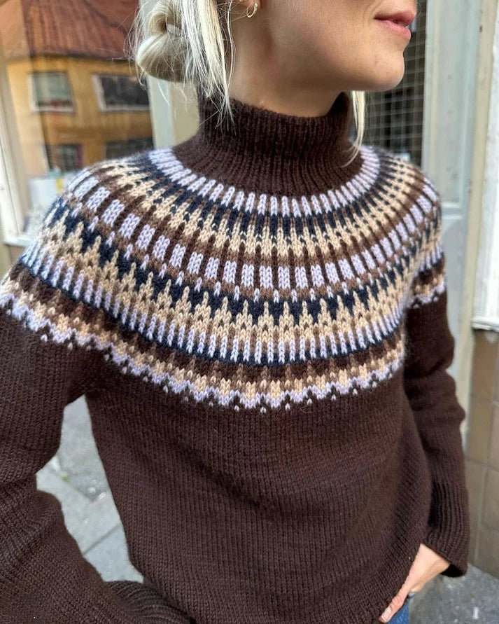 Celeste Sweater on näyttävä, moderni ja taidokkaasti suunniteltu kirjoneulevillapaita, jota koristaa upea pyöreä kaarroke.