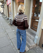 Celeste Sweater on näyttävä, moderni ja taidokkaasti suunniteltu kirjoneulevillapaita, jota koristaa upea pyöreä kaarroke.