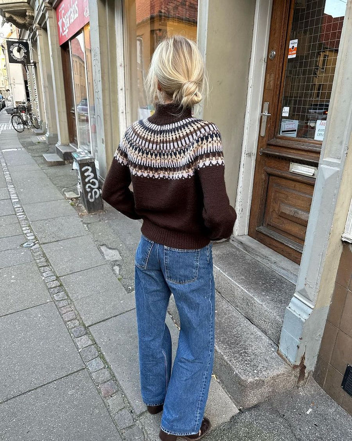 Celeste Sweater on näyttävä, moderni ja taidokkaasti suunniteltu kirjoneulevillapaita, jota koristaa upea pyöreä kaarroke.