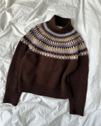 Celeste Sweater on näyttävä, moderni ja taidokkaasti suunniteltu kirjoneulevillapaita, jota koristaa upea pyöreä kaarroke.