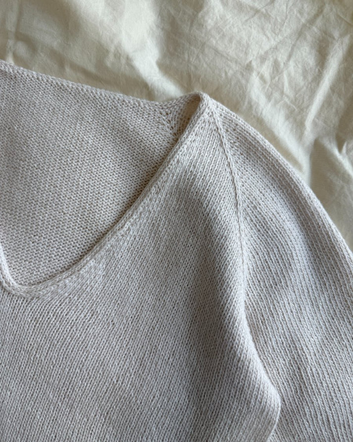 Cumulus Tee on siro, ilmava ja naisellinen lyhythihainen neulepaita, jossa on kauniisti pyöristetty V-pääntie.