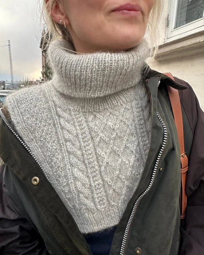 Moby Neck on näyttävä, lämmin ja tyylikäs palmikkokauluri, jota koristaa PetiteKnitin runsas ja eläväpintainen rakenne- ja palmikkoneule.