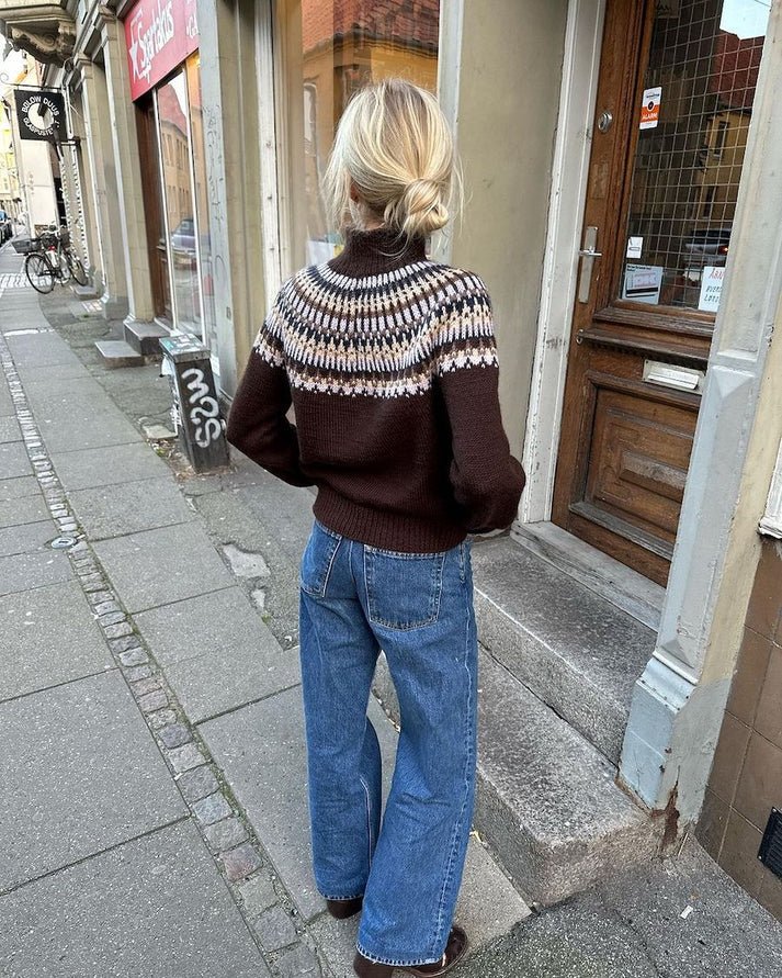 Celeste Sweater on näyttävä, moderni ja taidokkaasti suunniteltu kirjoneulevillapaita, jota koristaa upea pyöreä kaarroke.