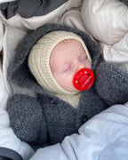 Selma’s Sleep Suit on suloinen, muhkea ja ihanan lämmin hupullinen vauvojen ja taaperoiden neulehaalari.