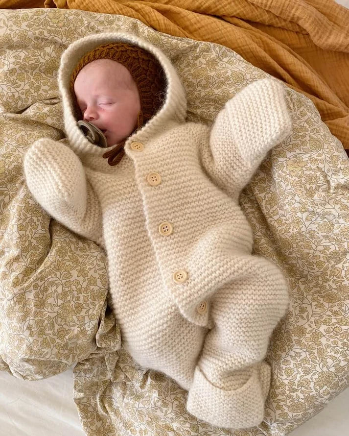 Selma’s Sleep Suit on suloinen, muhkea ja ihanan lämmin hupullinen vauvojen ja taaperoiden neulehaalari.