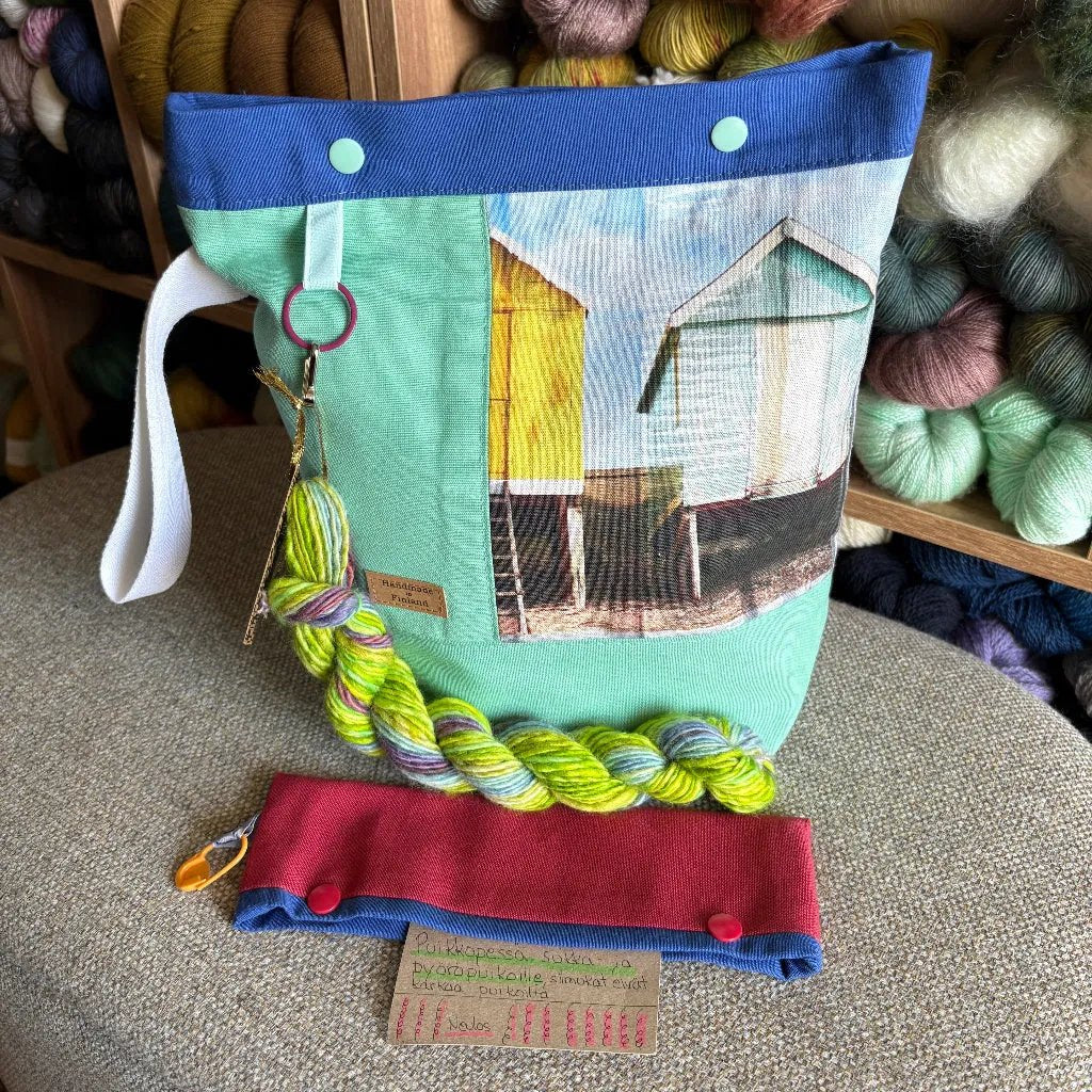 Carelia Handmade käsintehty sukkaprojektipussi ja nepparillinen puikkopesä pitävät työn ja silmukat tallessa. Mukana kehruukuitu- tai minilankanäyte!