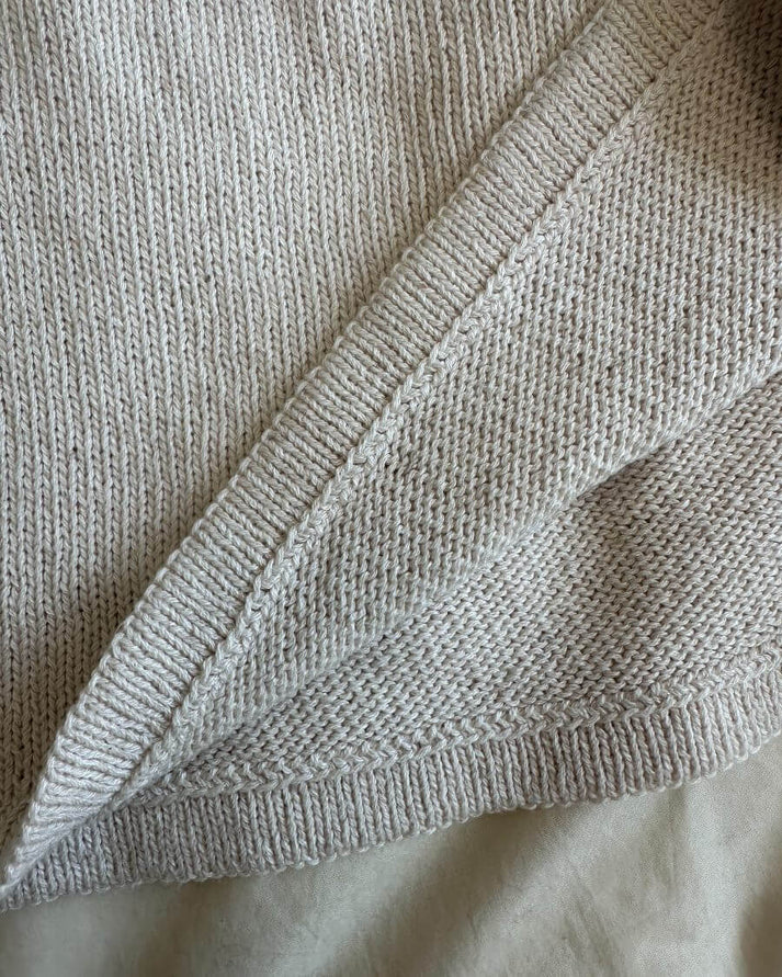 Sunday Tee on siro, naisellinen ja ajattoman kaunis lyhythihainen neulepaita, jota koristaa näyttävä ja joustava pyöreä joustinneulekaarroke.